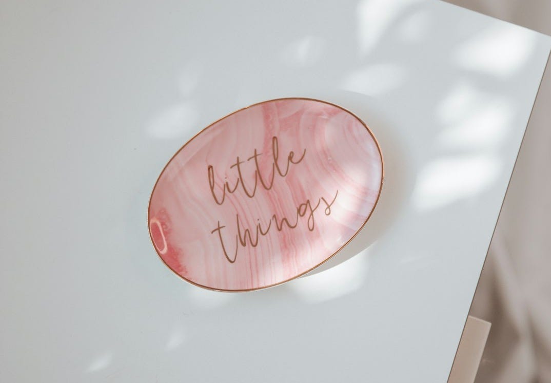 a white table with a pink plate with writing on it