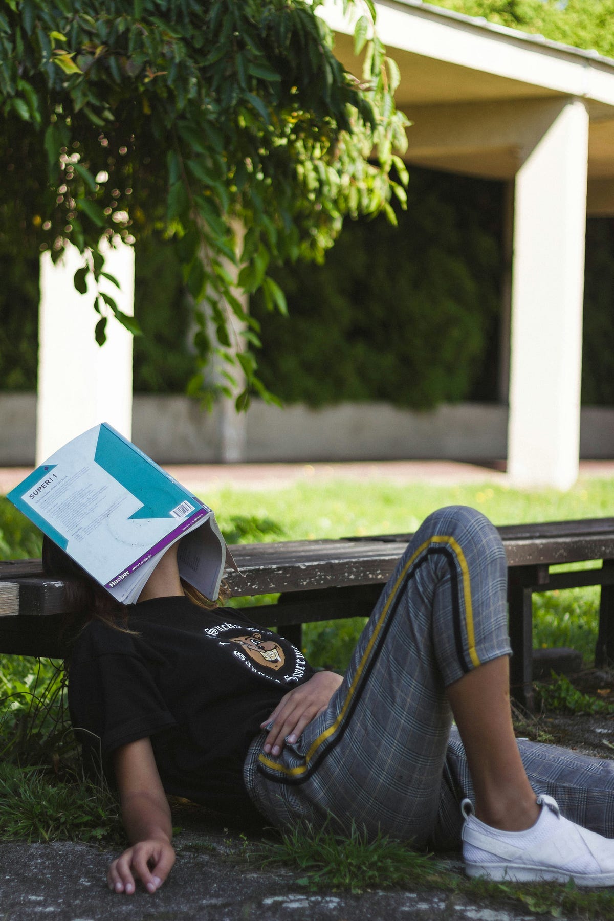 tired person sleeps with book on face