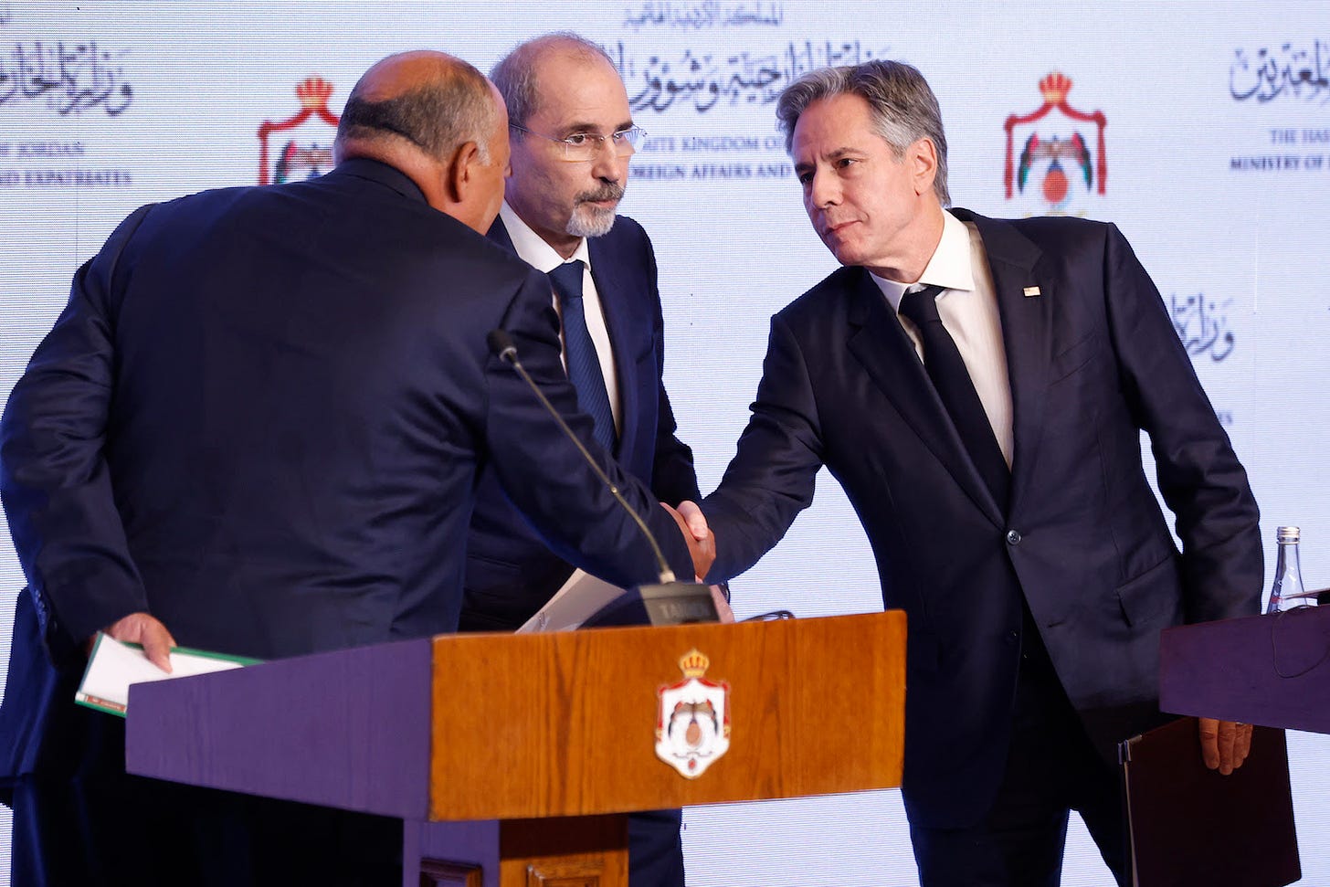U.S. Secretary of State Antony Blinken, Jordanian Foreign Minister Ayman Safadi, and Egyptian Foreign Minister Sameh Shoukry shake hands.