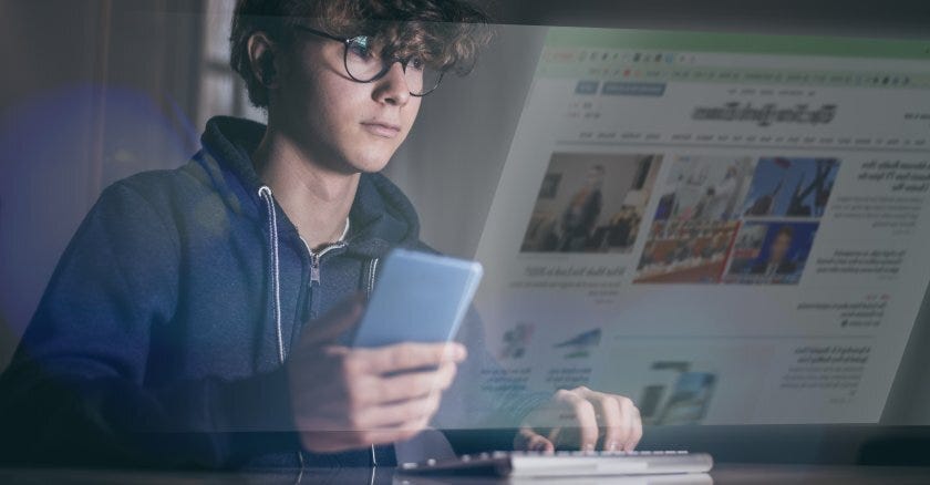 Teenager with phone, computer and newspaper