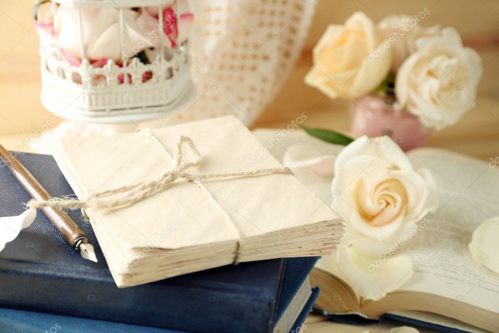 stack of letter envelopes with roses on desk