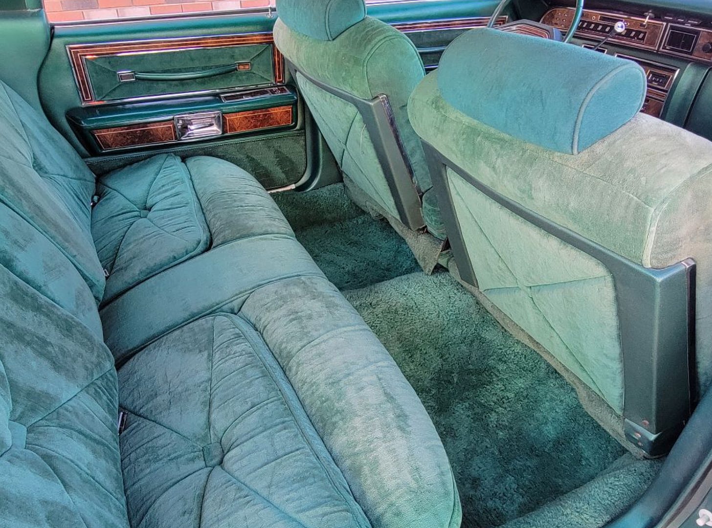 The soft jade upholstery of a Lincoln Continental's back seat.