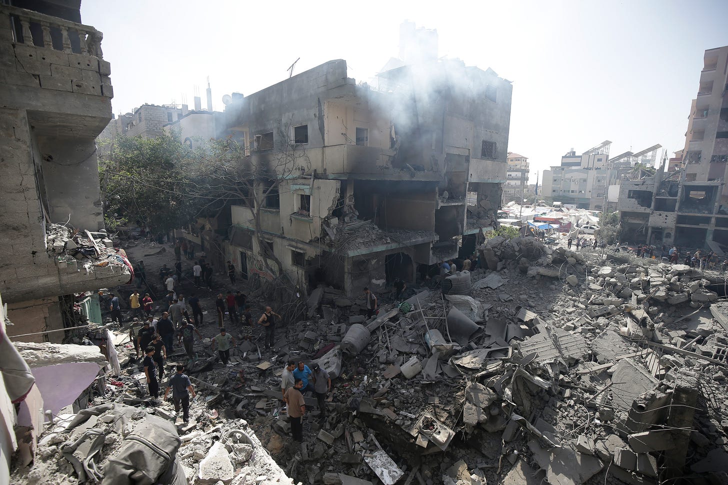 Palestinians look at the aftermath of Israeli attacks in Nuseirat refugee camp, Gaza, on Saturday, June 8. 