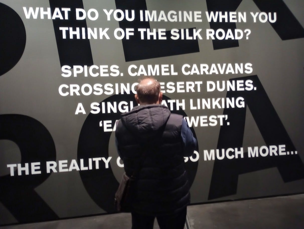 Man standing in front of several sentences painted on wall