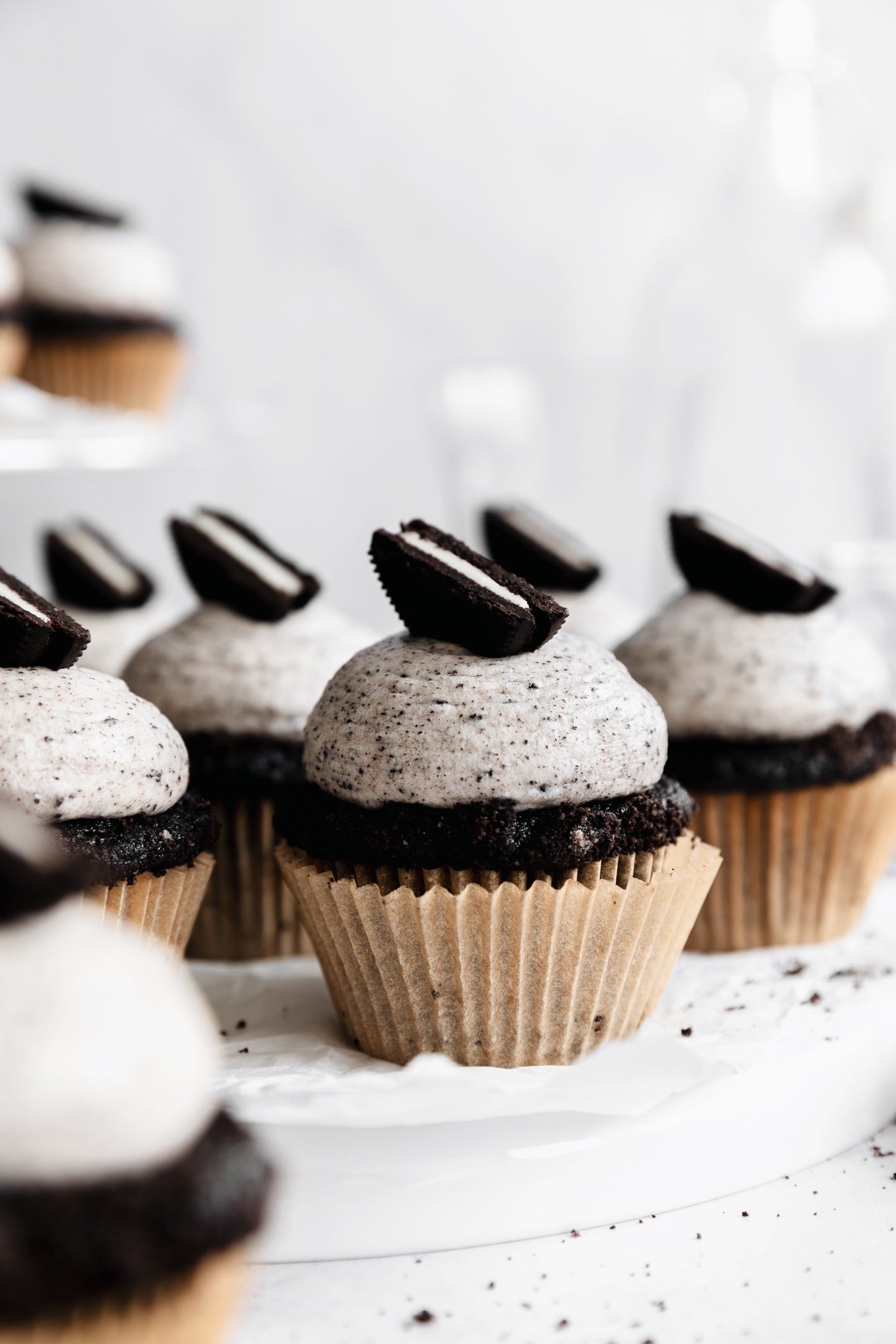 Plate of vegan cookies & cream cupcakes on white background
