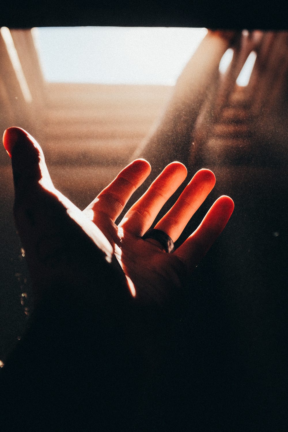 A hand reaching into the light and dust of a kiva in New Mexico