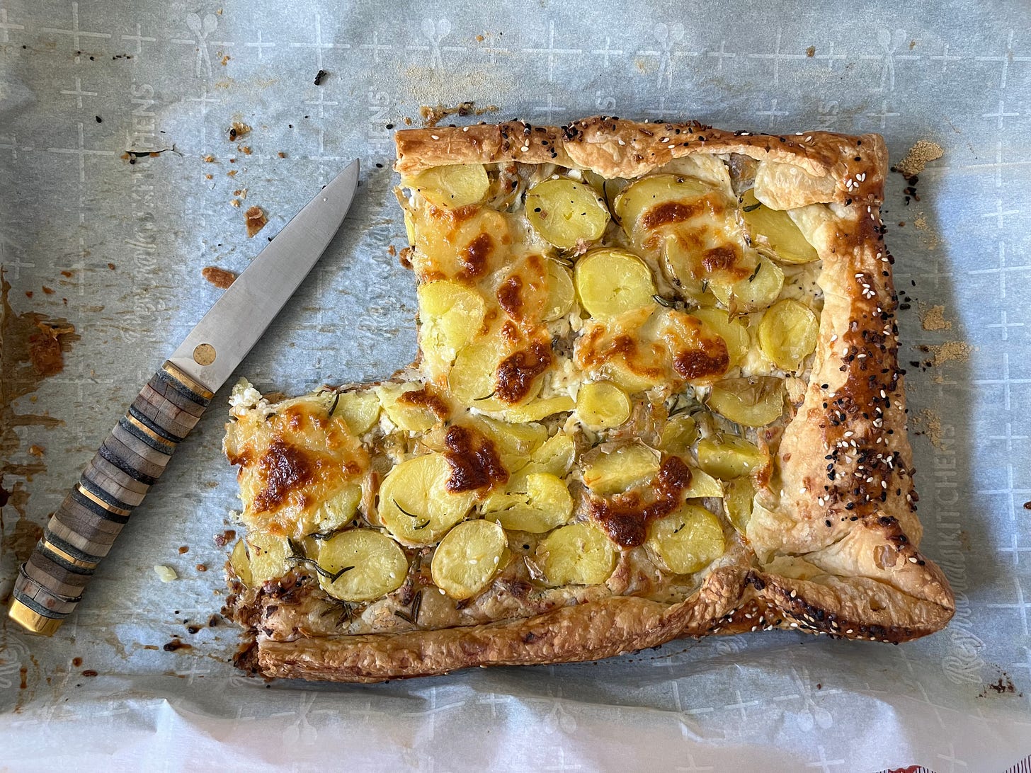 An overhead view of the galette, with slices already removed an a knife nearby to slice more.