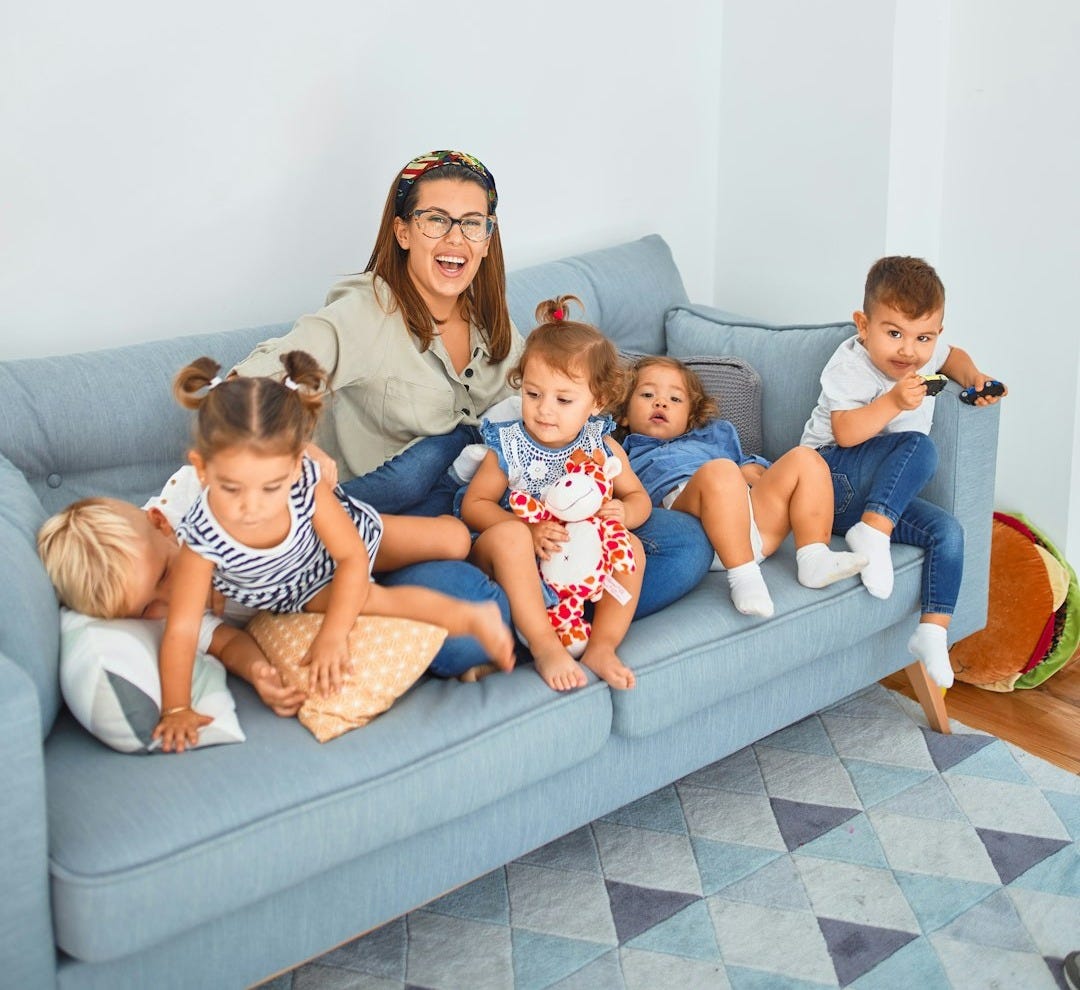 3 women sitting on gray couch 3 women sitting on gray couch