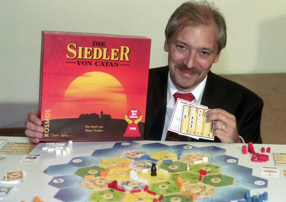 FILE - Klaus Teuber, a dental technician from Darmstadt, presents his game "The Settlers of Catan", Friday, Sept. 29, 1995, in Frankfurt, Germany. Teuber, creator of the hugely popular Catan board game in which players compete to build settlements on a fictional island, passed away on April 1, 2023 after a short and serious illness, according to a family statement. He was 70. (AP Photo/Bernd Kammerer, File)