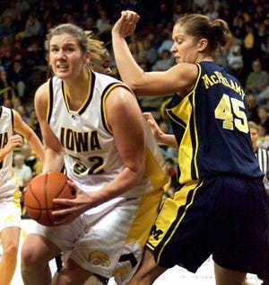 Iowa's Jamie Cavey, left, drives around Michigan's BreAnne McPhilamy during a Hawkeye victory on Jan. 25, 2004, at Carver-Hawkeye Arena in Iowa City.