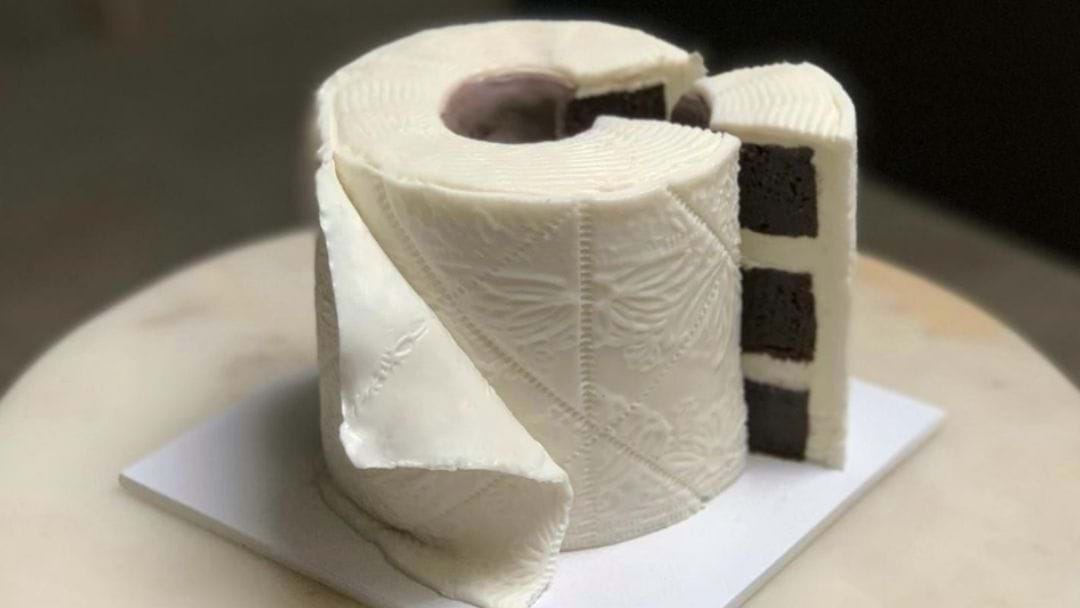 Rolo de papel aparentemente normal, porém vemos um corte de uma fatia de bolo de chocolate na lateral. É apenas um bolo realista.