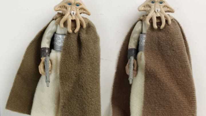 Two Star Wars action figures of Tessek the Quarren with his brown robe and blaster. His face has squid-like pincers and tentacles.