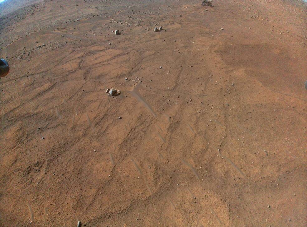 This image of NASAs Perseverance Mars rover â€“ visible at the top, right of center â€“ was taken at an altitude of about 16 feet (5 meters) by the Ingenuity Mars Helicopter during its 54th flight on Aug. 3, 2023.
