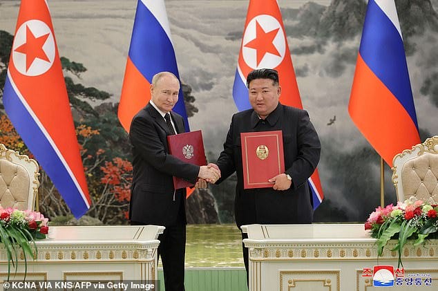 Kim Jong Un (R) and Russia's President Vladimir Putin (L) shaking hands after a signing ceremony following their bilateral talks on June 19