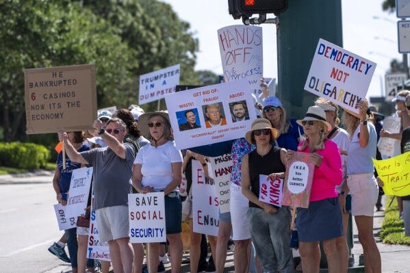 Activists protest President Donald Trump, who was a few miles away at his Trump National Golf Club, during a "Hands Off!" demonstration Saturday, April 5, 2025, in Palm Beach Gardens, Fla. (AP Photo/Alex Brandon)