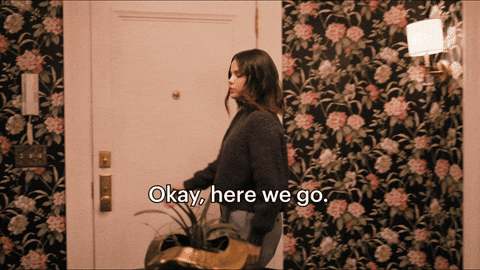Selena Gomez in Only Murders in the Building starting to open a door and saying, "Okay, here we go."