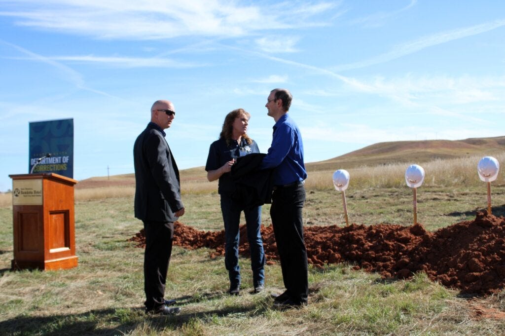 From left, Pennington County Sheriff Brian Mueller, South Dakota Secretary of Corrections Kellie Wasko and Ryan Brunner, senior policy adviser and director of legislative relations for Gov. Kristi Noem, participate in a groundbreaking ceremony for a women's prison Oct. 16, 2023, in Rapid City. (Seth Tupper/South Dakota Searchlight)