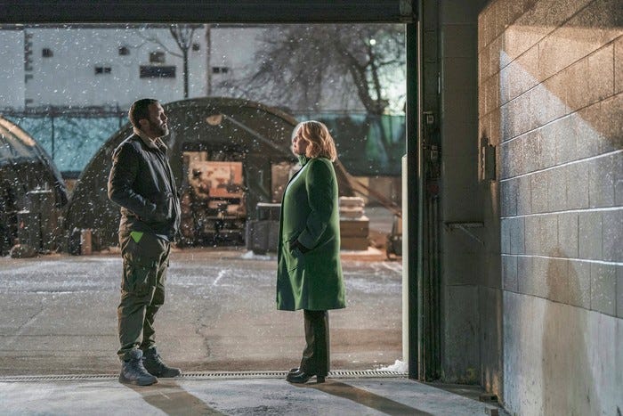 Elisabeth Moss as June and O-T Fagbenle as Luke, standing facing one another outside, talking.