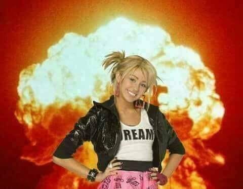 This may contain: a woman standing in front of an explosion with her hands on her hips and looking at the camera