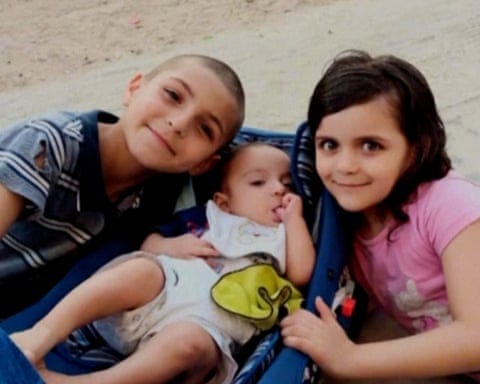 Adam al-Najjar, who survived the strike, with sisters Sidra and Eve, two of the children killed.