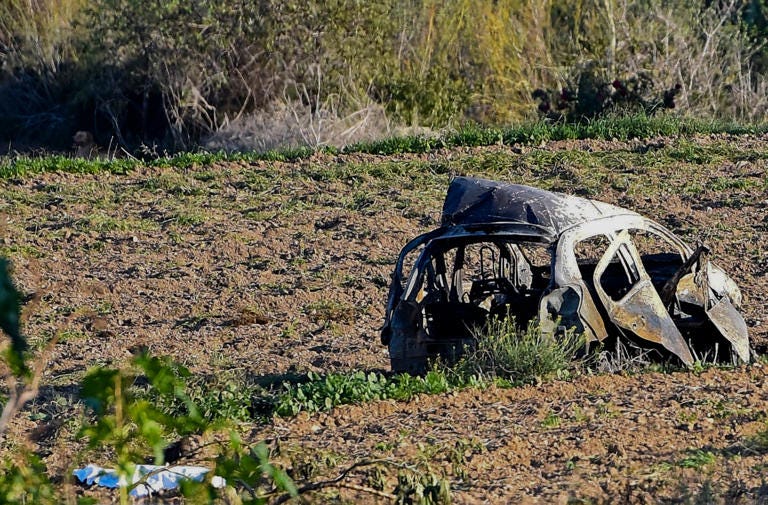 FILE - The wreckage of the car of investigative journalist Daphne Caruana Galizia lies next to a road in the town (Copyright 2022 The Associated Press. All rights reserved.)