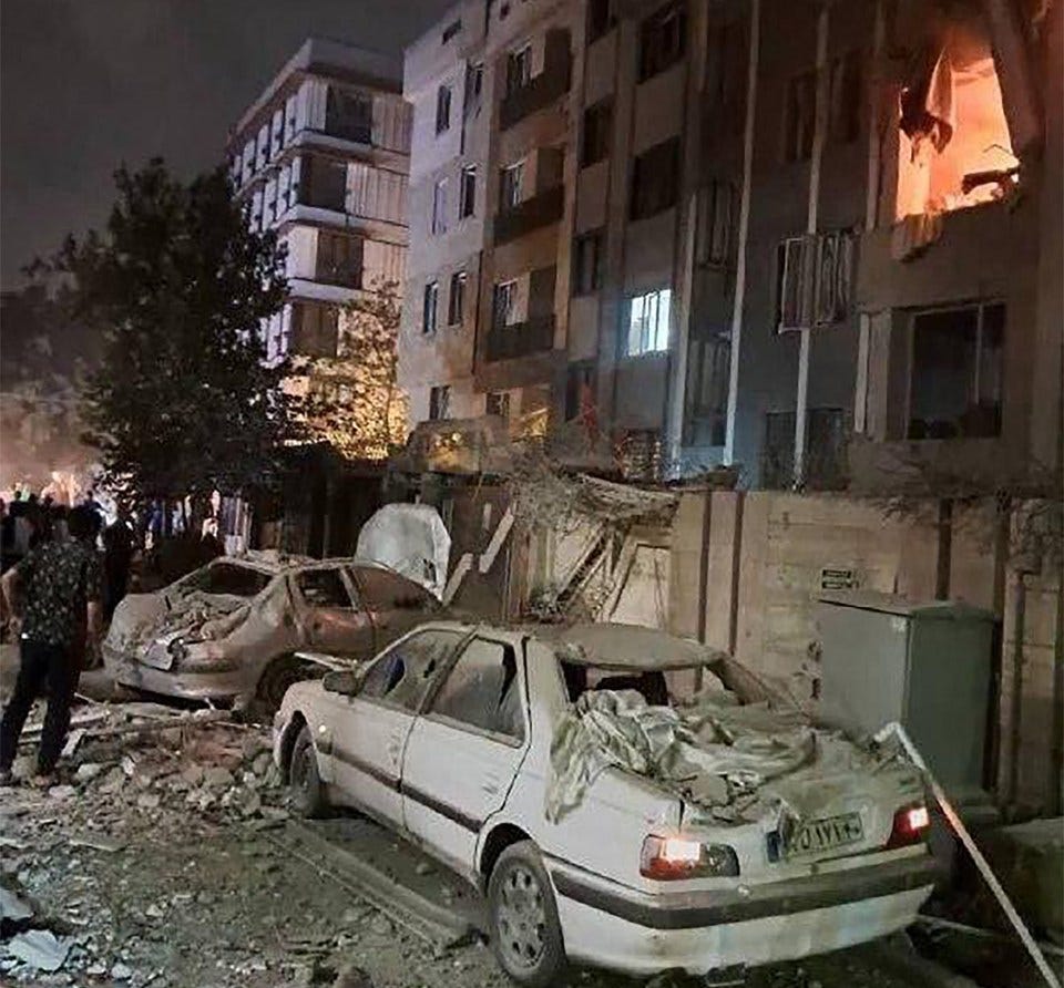 Damage to a Tehran building and cars following an Israeli strike.