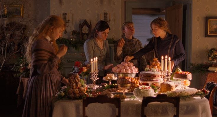 This may contain: a group of women standing around a table with food on top of it and candles in front of them