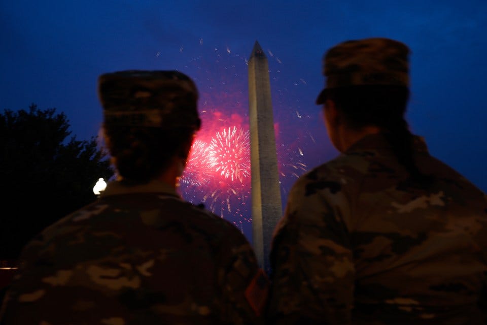 Two soldiers watch fireworks over the Washington Monument.