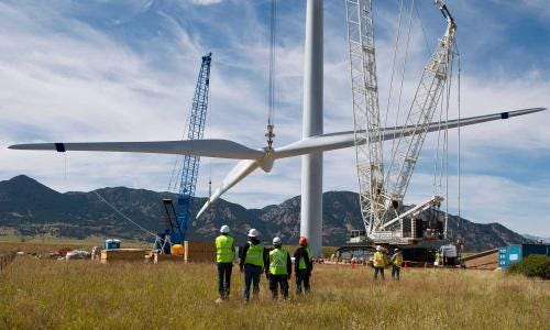 A wind turbine being erected with workers