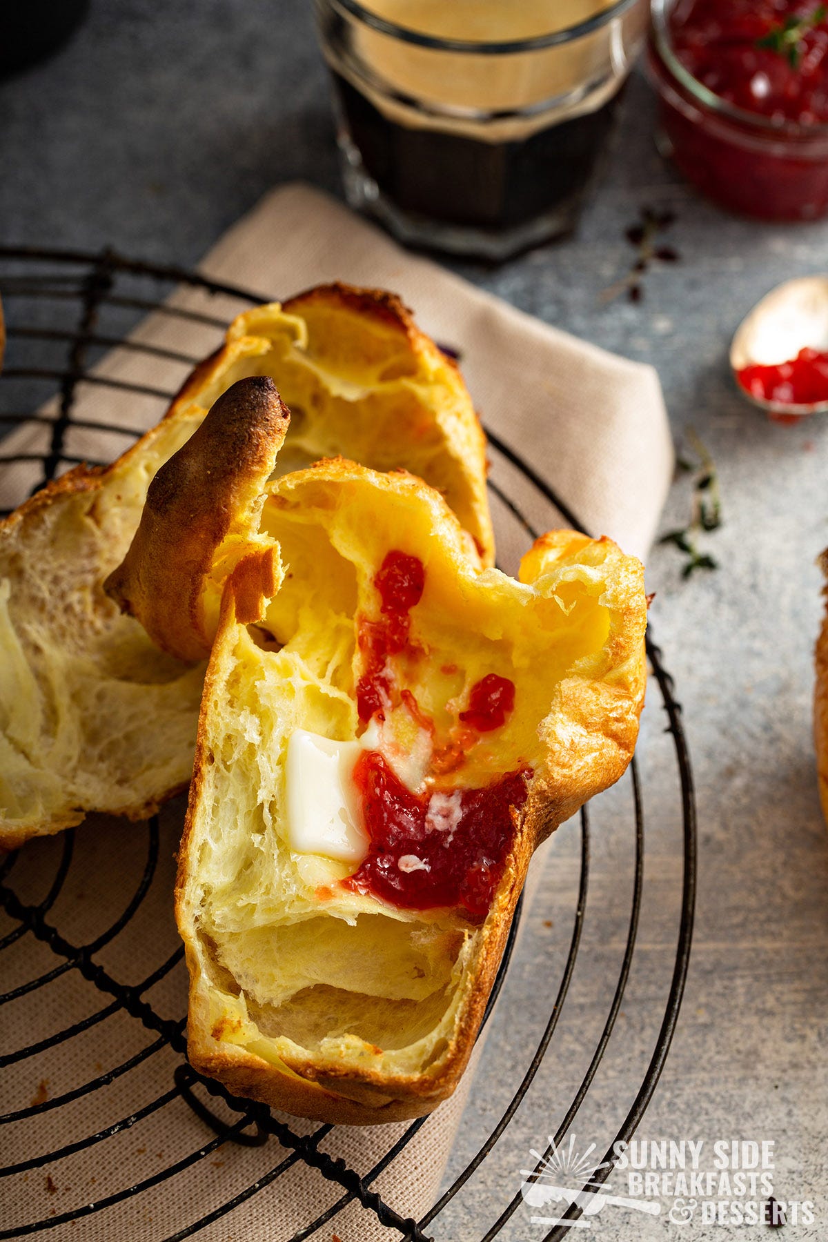 A popover split in half with butter and jam.