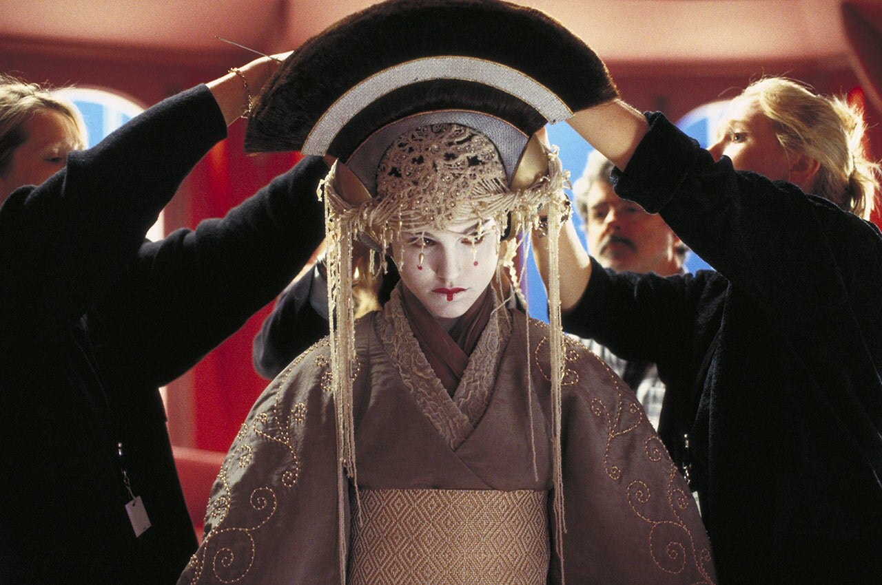 A group of costume department people help assemble Queen Amidala's headdress