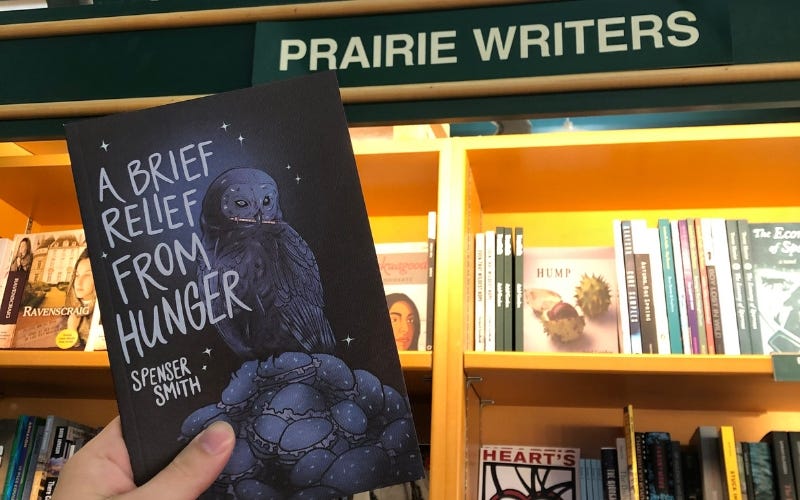 A person holding "A brief relief from hunger" in a bookstore in front of the "Prairie writers" section.