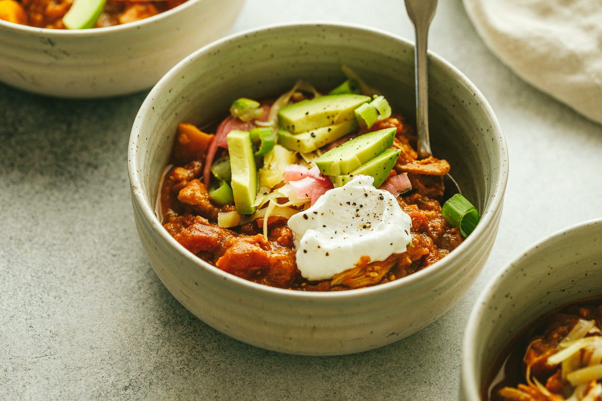 Autumn chicken chili in a ceramic bowl with a spoon.