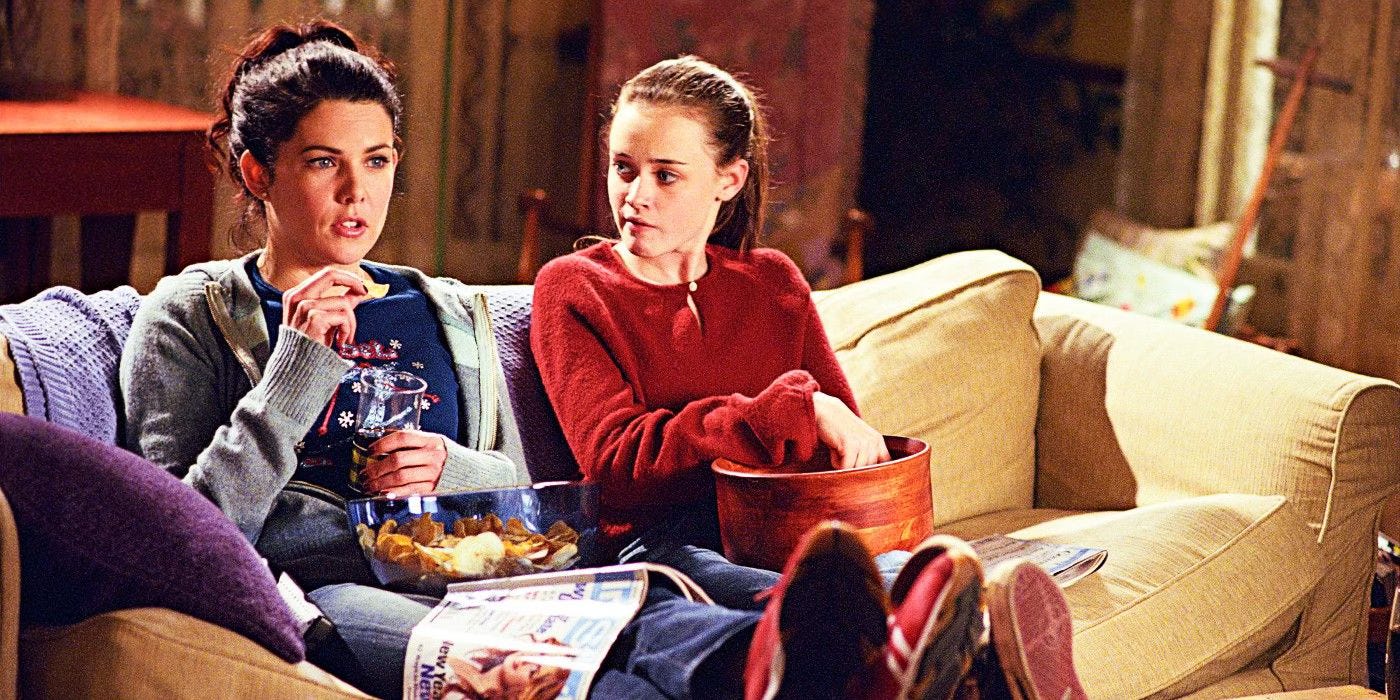 Lorelai and Rory Gilmore snack on the couch and watch TV. 