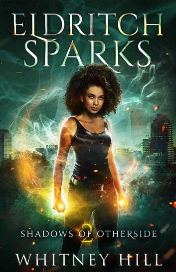 Cover of Eldritch Sparks by Whitney Hill. A power Black woman with an afro with a black camisole and black jeans. Conjuring yellow/orange magic with a city in the background.