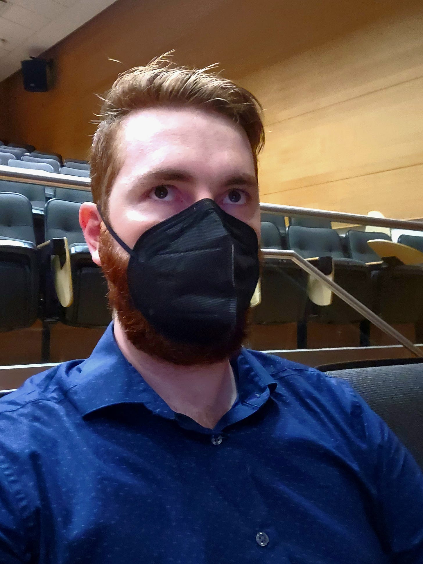 Me sitting in the auditorium wearing a mask with a look oif complete befuddlement
