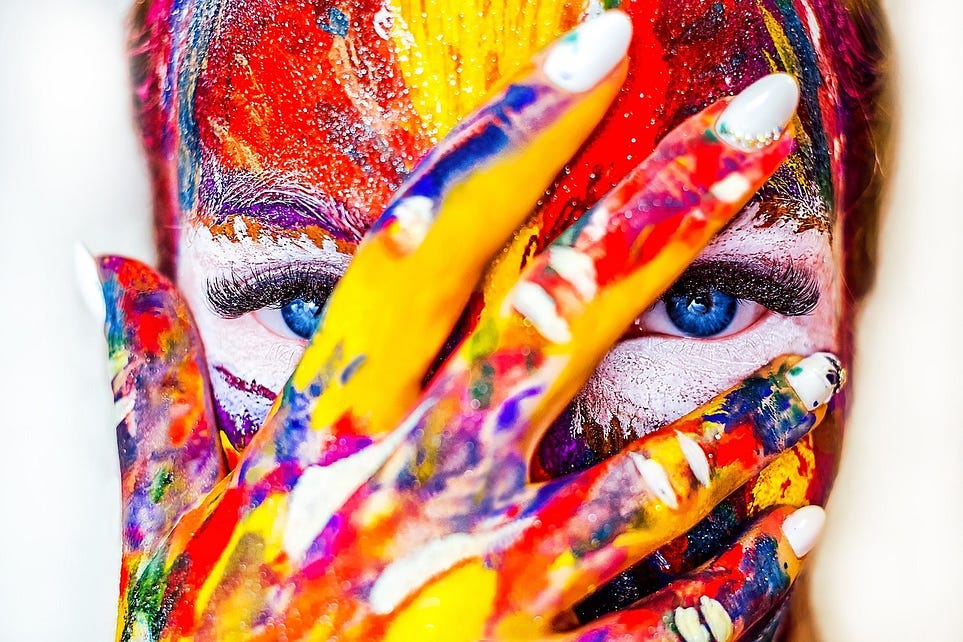 A woman’s face covered in bright paint