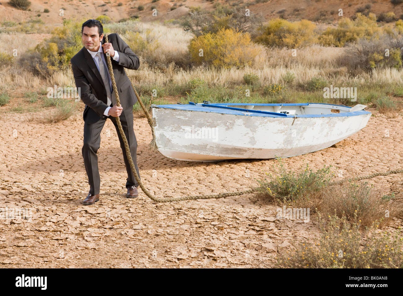 Businessman towing a boat in the desert Stock Photo - Alamy