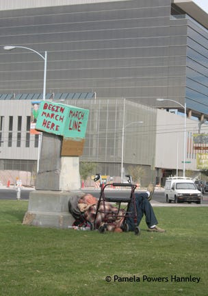 A homeless man sleeps in the shadow of corporate America.