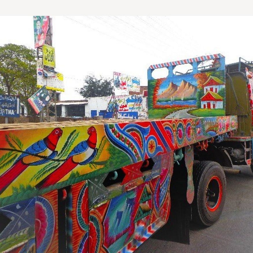 A beautifully hand-painted open flat bed truck in Pakistan. painted brids in the foreground