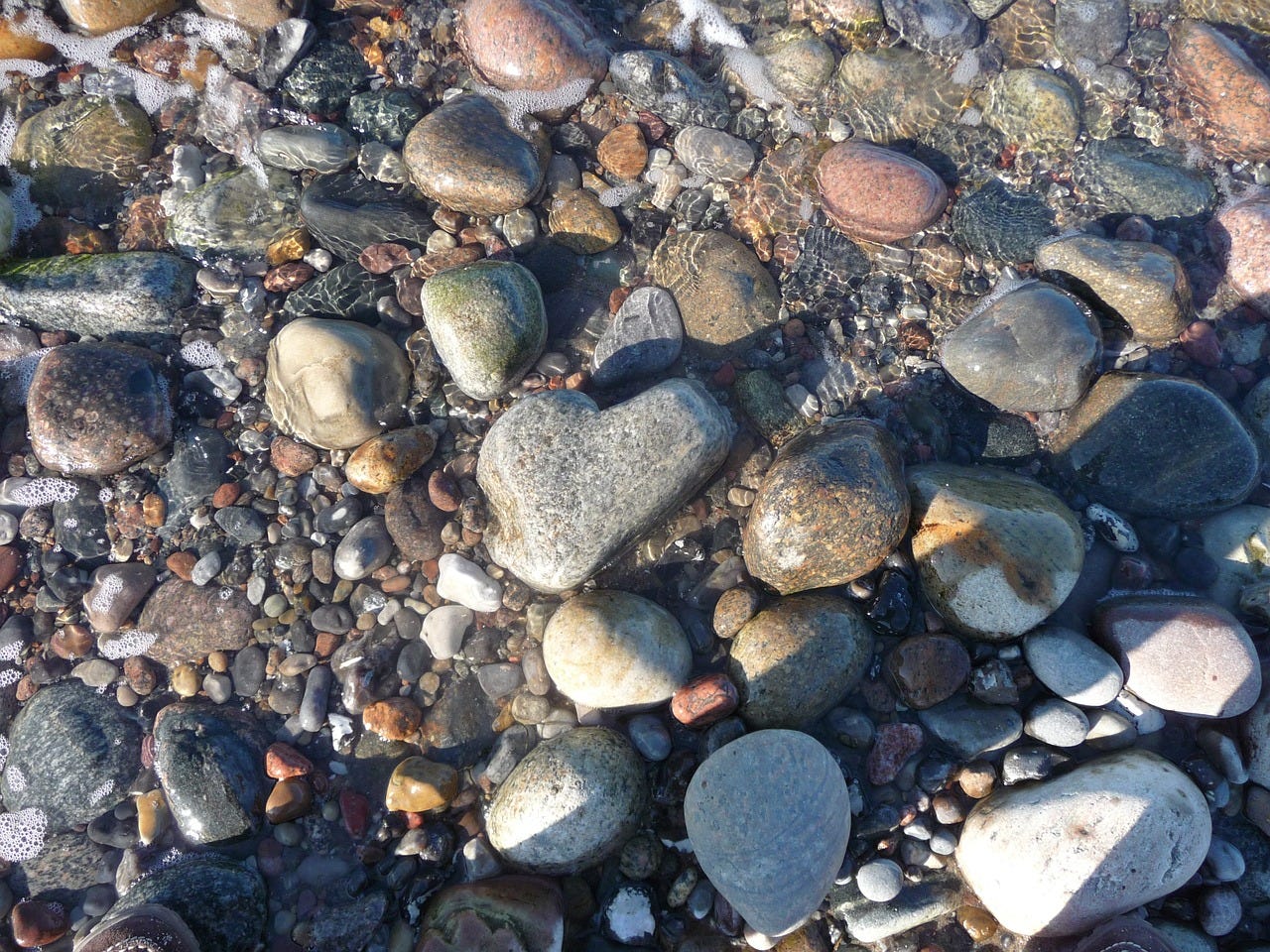 heart shaped stone among other stones on beach
