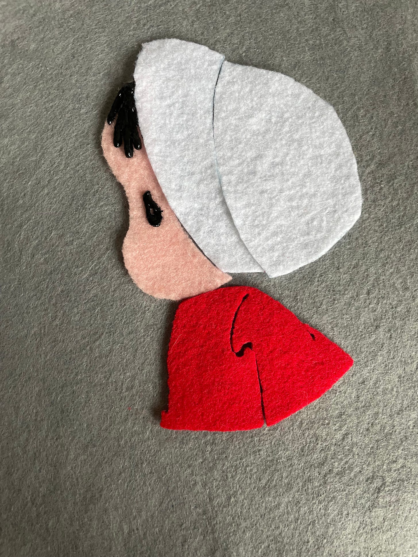 a felt piece of a precious moments figure in the style of the handmaids tale