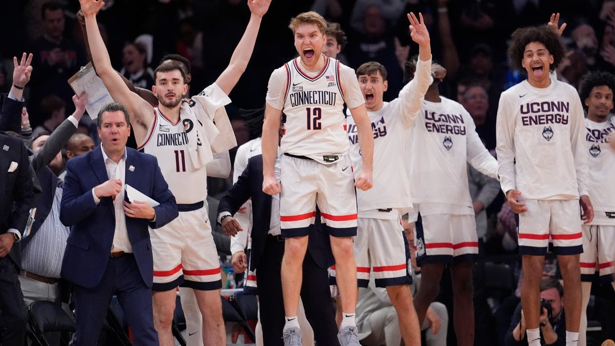 UConn guard Cam Spencer (12) and teammates celebrate during the final minutes of the team's NCAA college basketball game against Marquette for the championship of the Big East men's tournament Saturday, March 16, 2024, in New York.