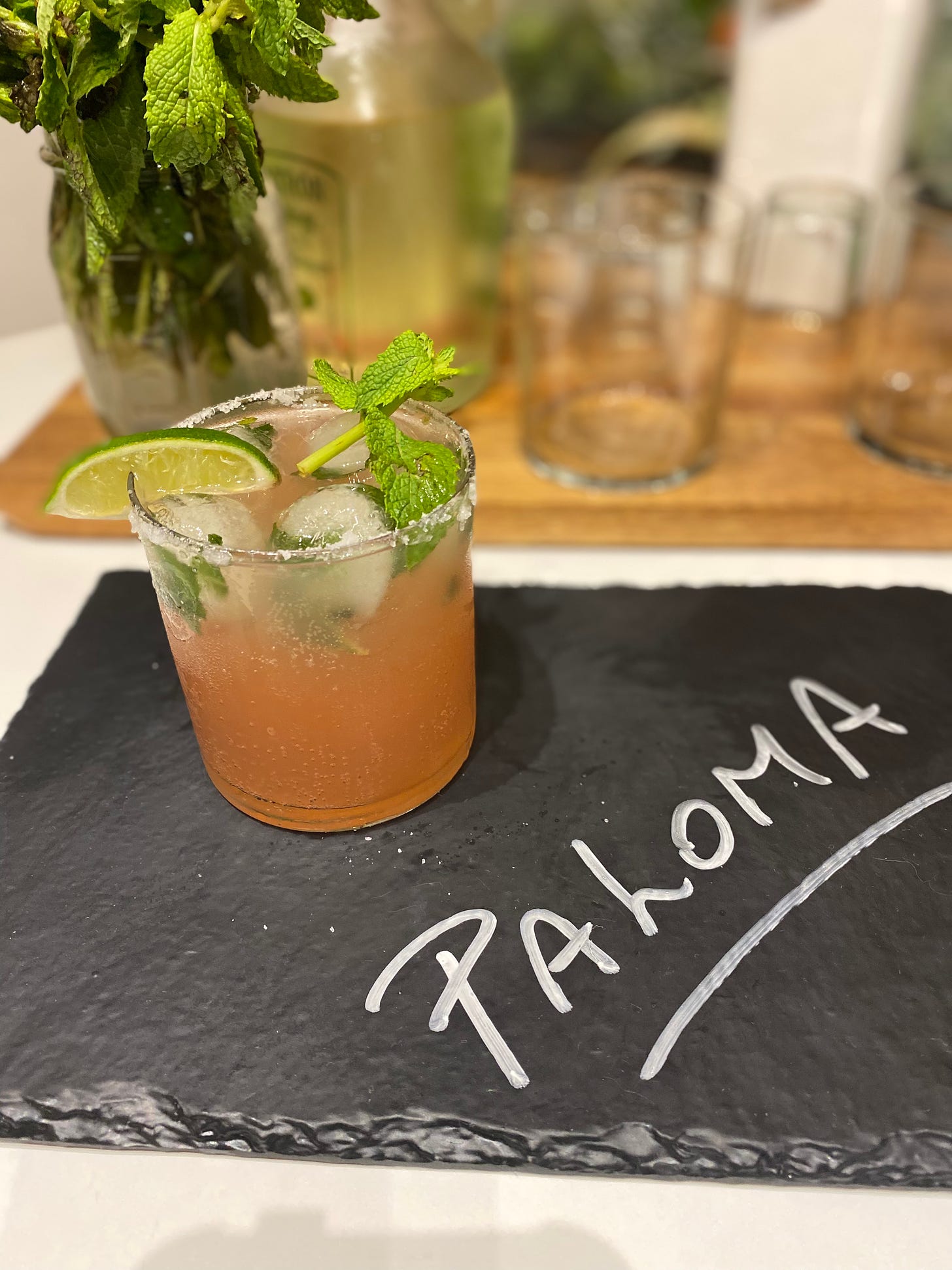 A Paloma drink made with grapefruit soda and topped with mint