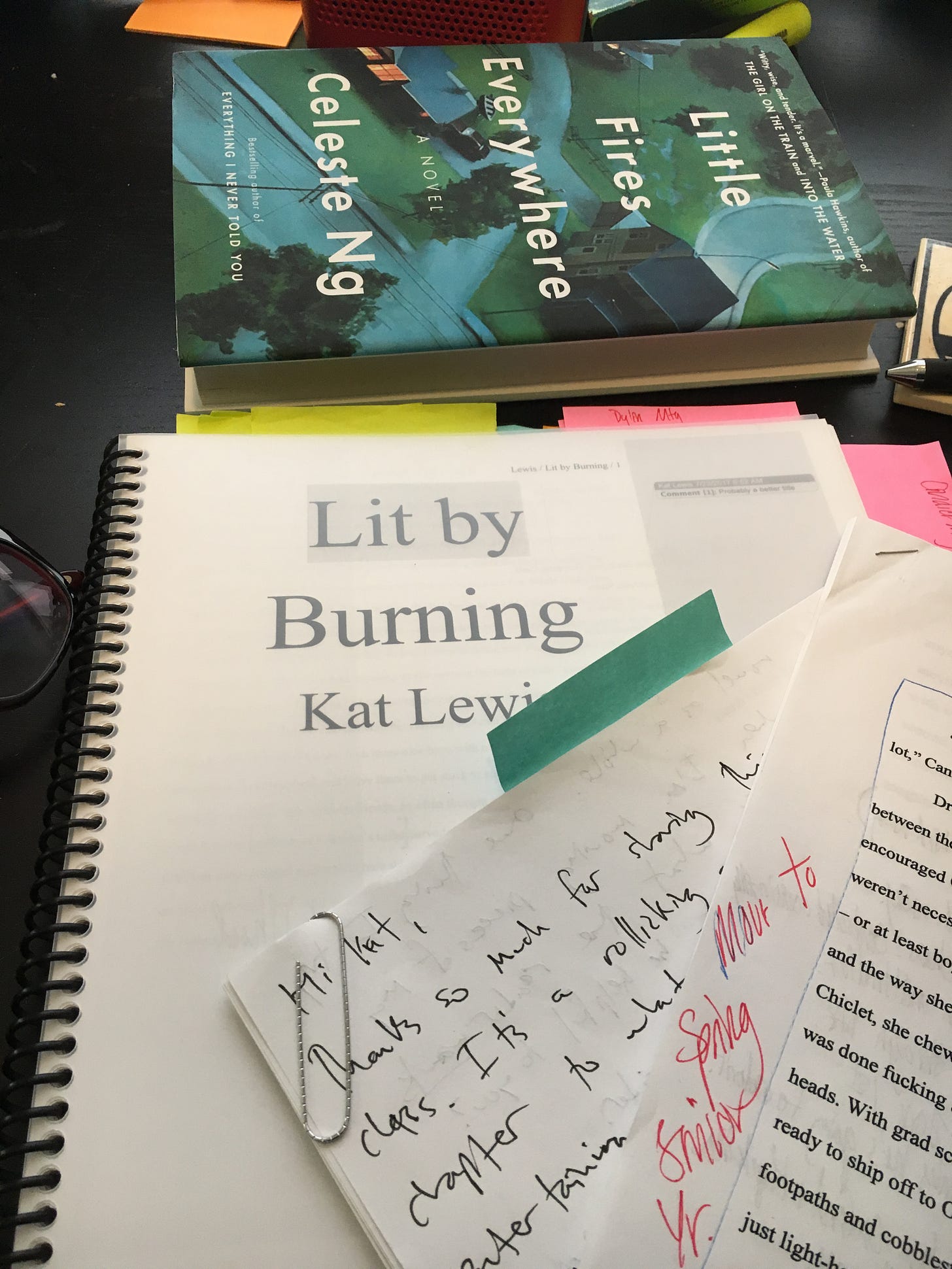 A printed and bound manuscript of Good People’s first draft, previously titled Lit by Burning. Next to the print-out is a copy of Celeste Ng’s Little Fires Everywhere and a partial excerpt of a handwritten workshop letter addressed to Kat.