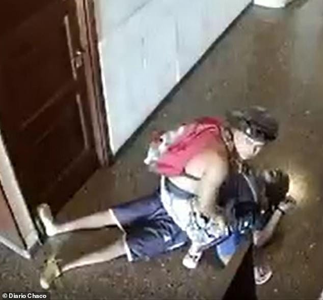 A suspect takes looks towards the building entrance before robbing a 54-year-old tourist who collapsed in the lobby before dying of a heart attack in Mar de Plata, Argentina, on Sunday