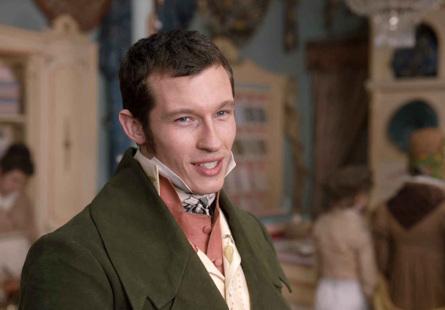 Callum Turner is Frank Churchill in Autumn de Wilde’s 2020 EMMA. Sporting a haircut right out of Adam Smith. In this photo he is seen close up, wearing a smart suit, a cravat, and sporting a mischievous smile. Charming! 