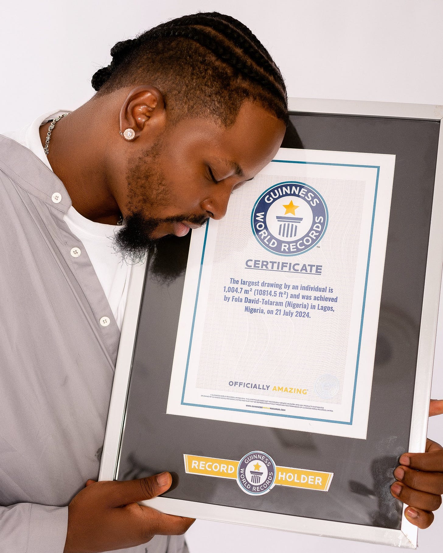 Record-breaker Fola David with his GWR certificate for the longest drawing by an individual