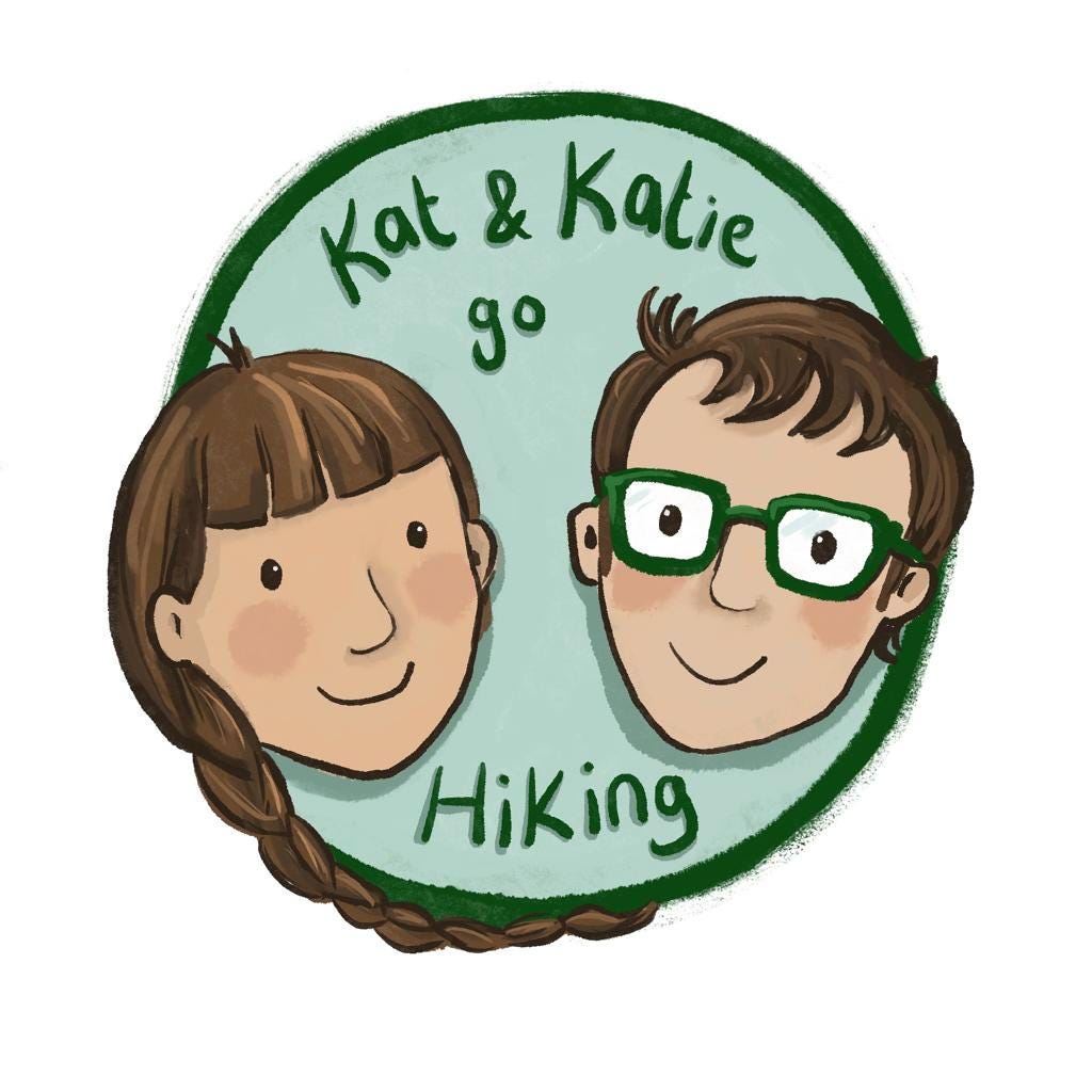 A hand drawn logo consisting of a pale blue circle with cartoon faces of two white people, one with long hair and a fringe and one with short hair and glasses. Both are smiling, and the green text reads “Kat and Katie go Hiking” 