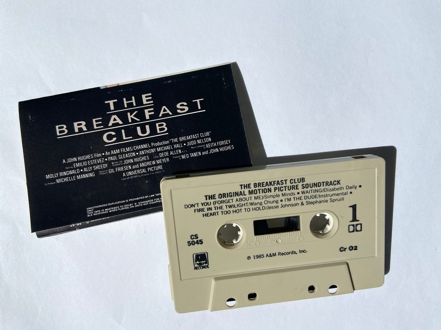 the J card insert for a cassette of the soundtrack for The Breakfast Club rests under the cassette tape.